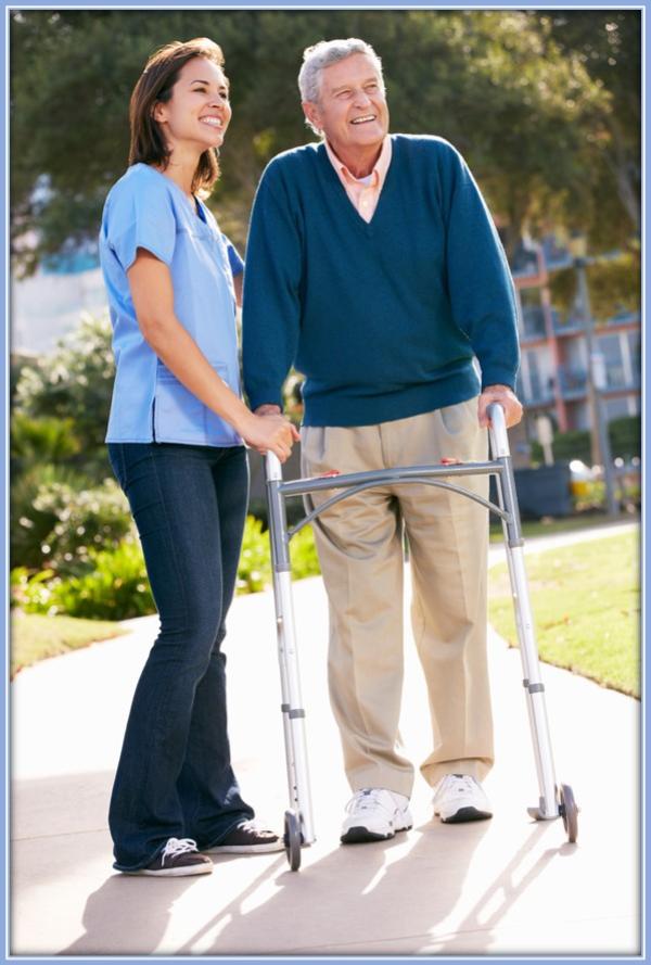 caregiver helping man walk with walker